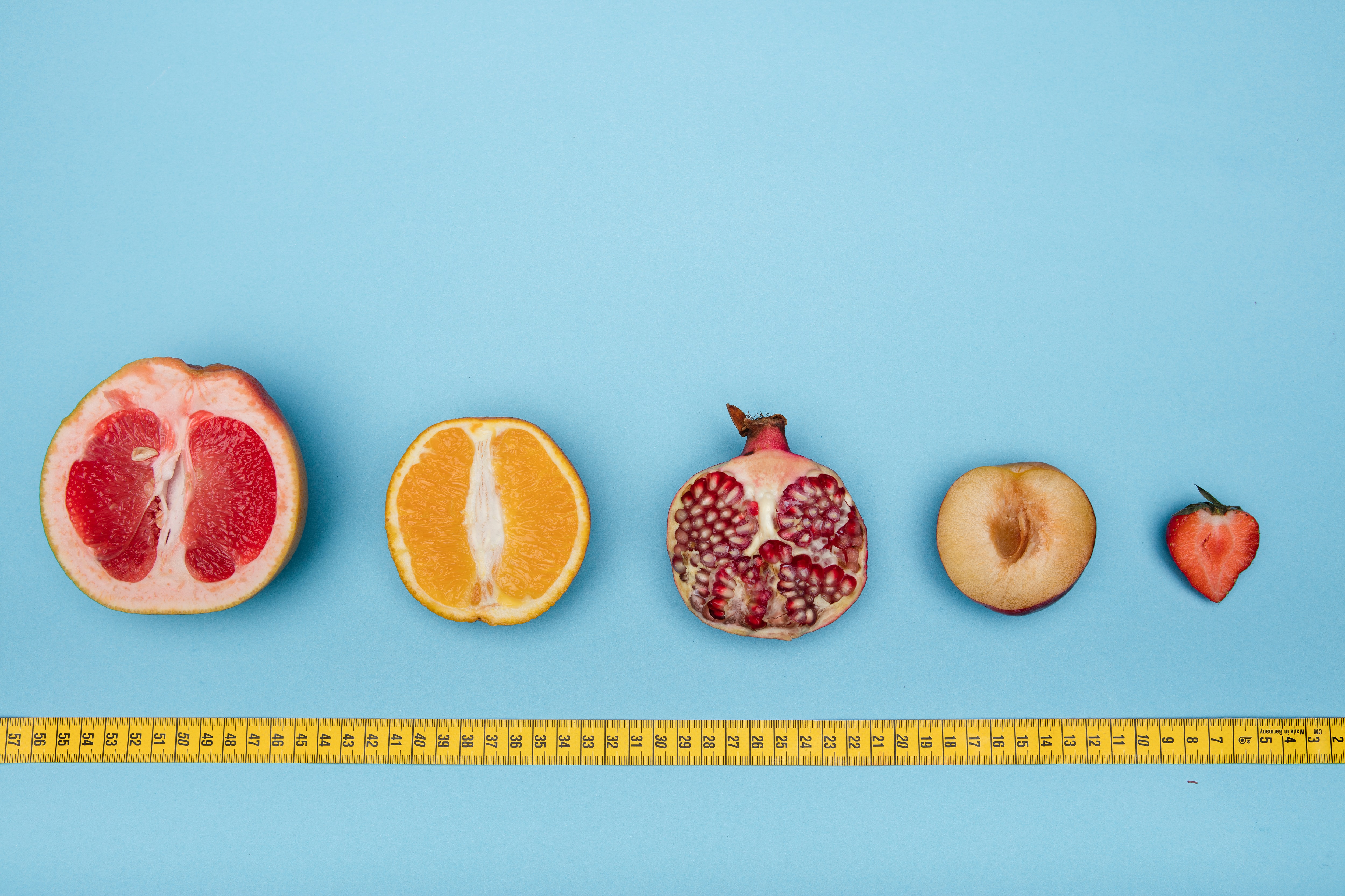 Different sized fruit with measuring tape