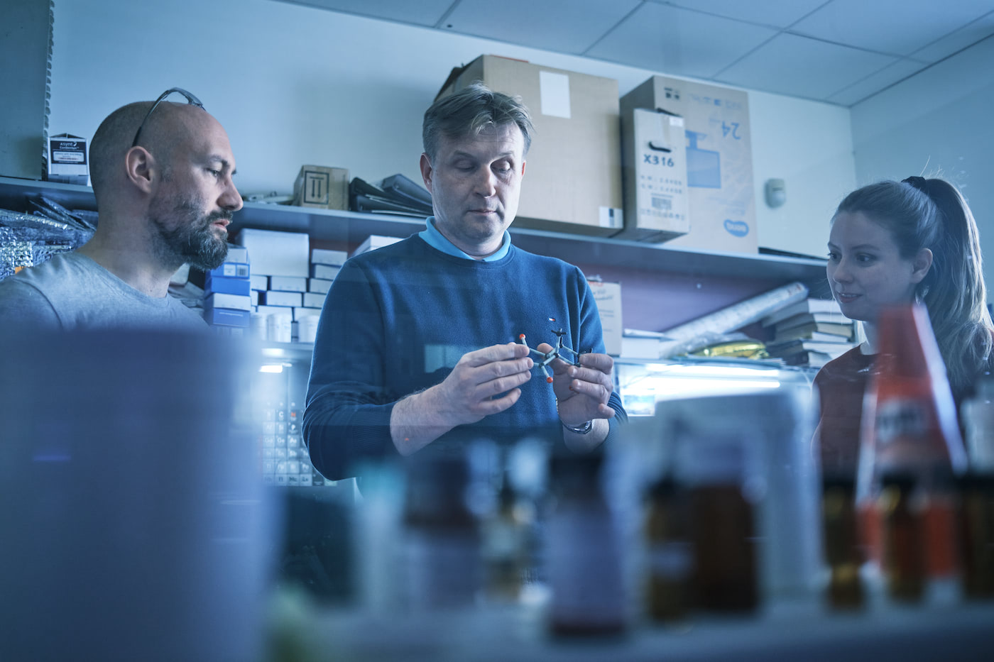 A photograph of Kamil Paruch, associate professor of organic chemistry at Masaryk University, with two researchers in CasInvent Pharma's lab looking at a 3D model of a chemical compound. Paruch is head of chemistry at CasInvent Pharma. 