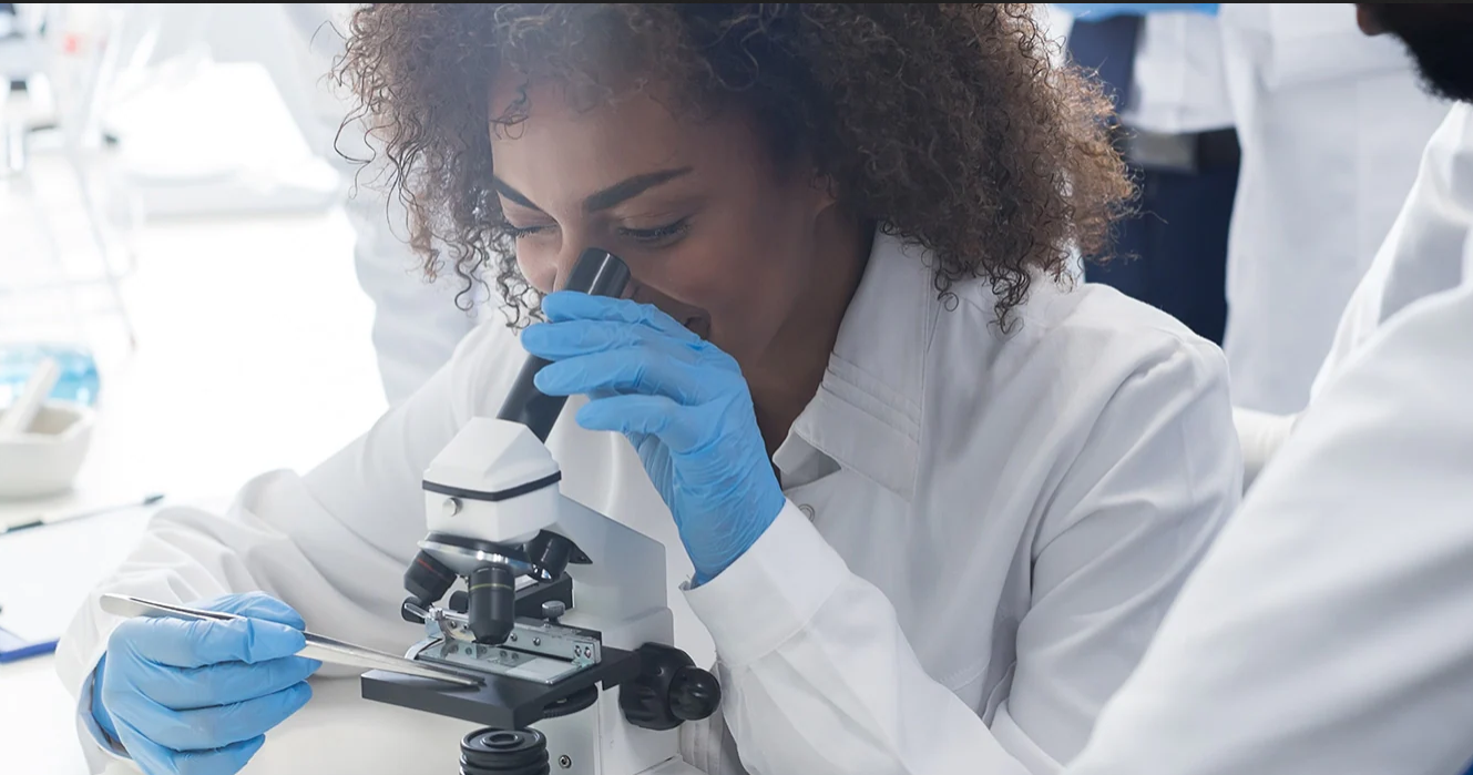 Female scientist looking down a microscope