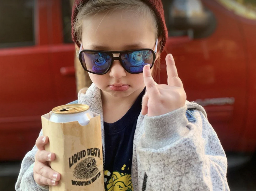 Young girl holding liquid death can