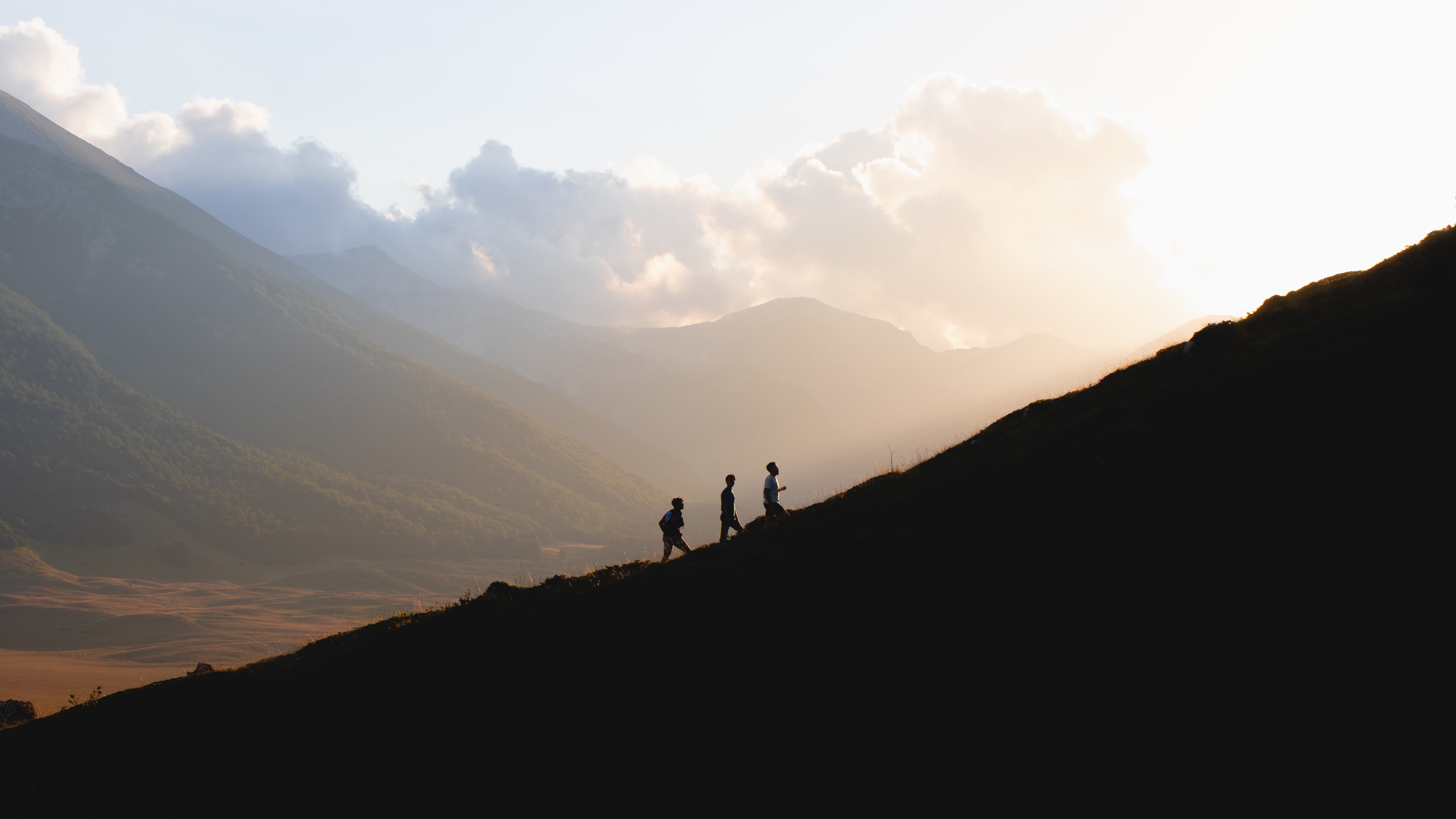 three men hiking up a mountain