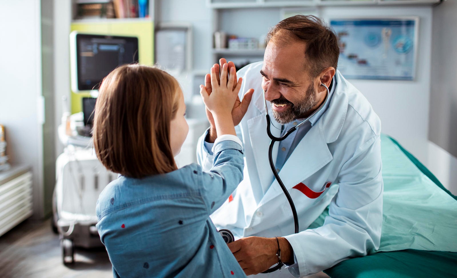 Doctor giving high five to young female cancer patient