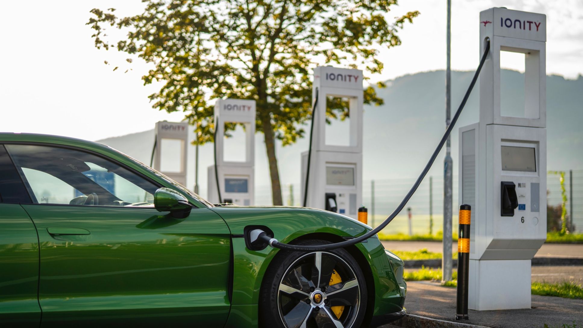 Green Porsche Taycan at EV charging point