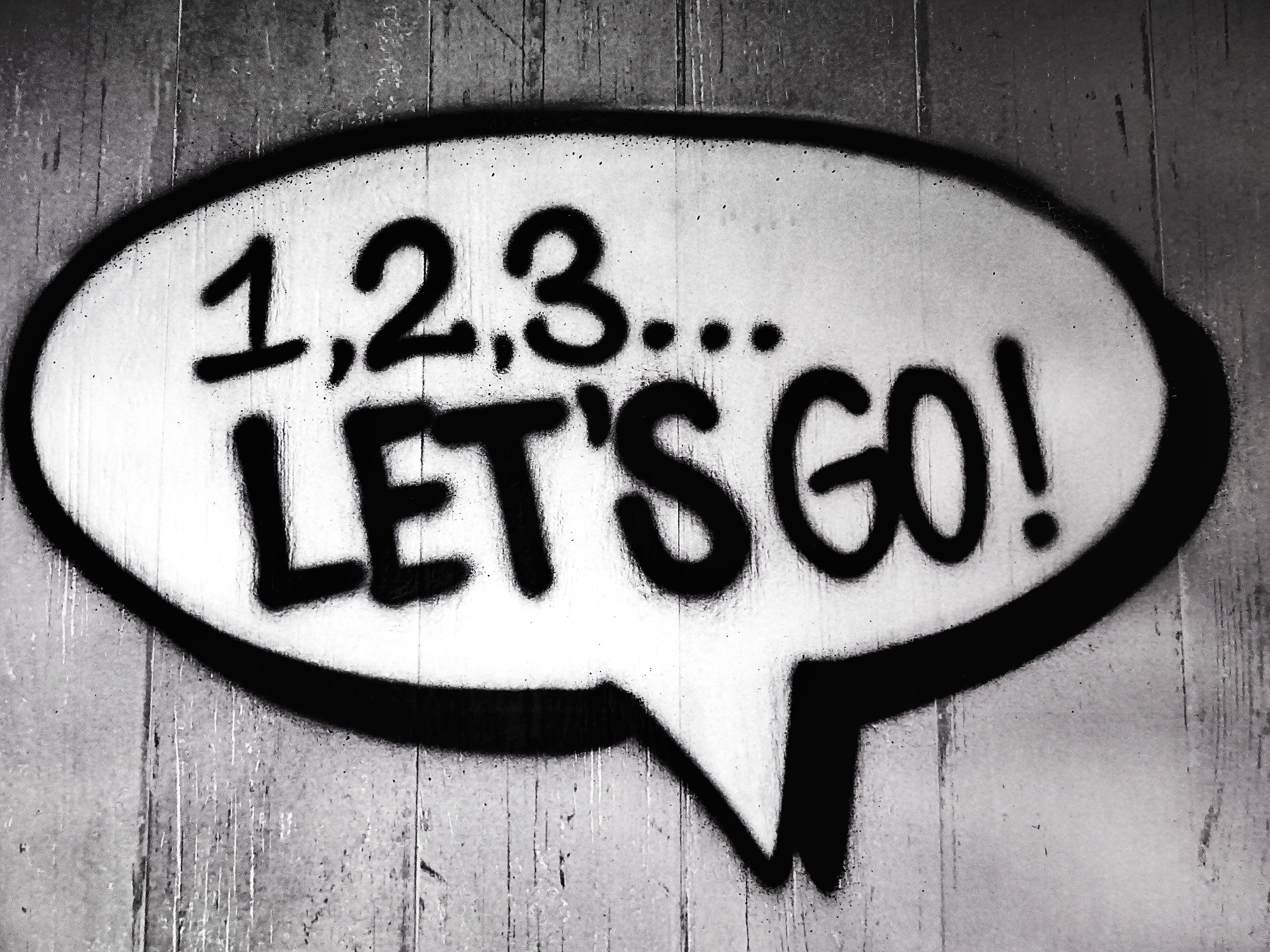 a black and white graffiti of a speech bubble readinng “1, 2, 3… let's go!"