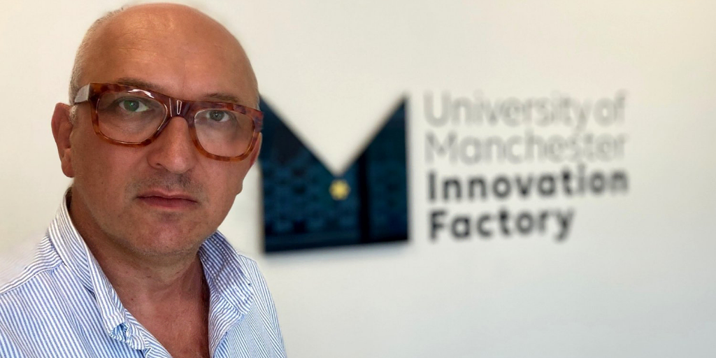 Andrew Wilkinson standing in front of a wall showing the Manchester Innovation Factory logo