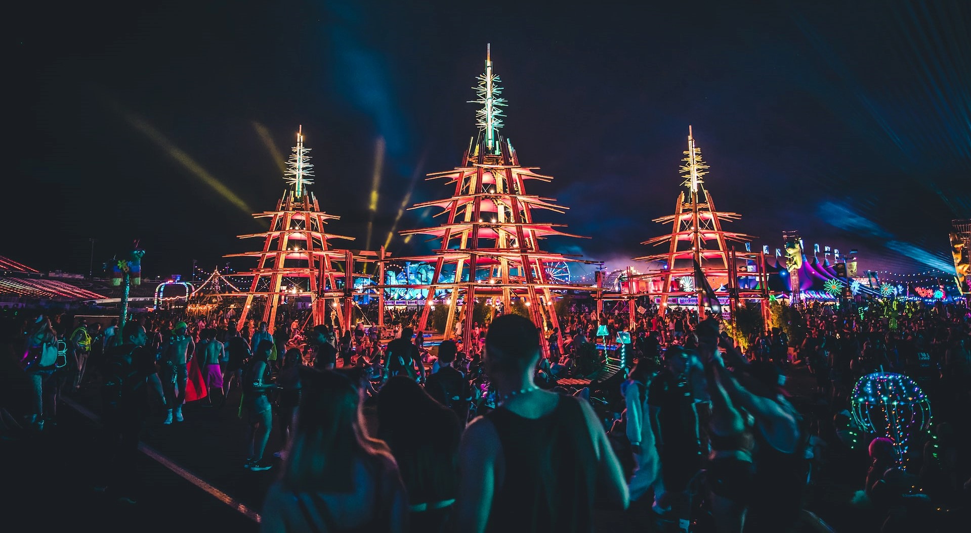 Crowd of outdoor clubbers in front of light installations at night