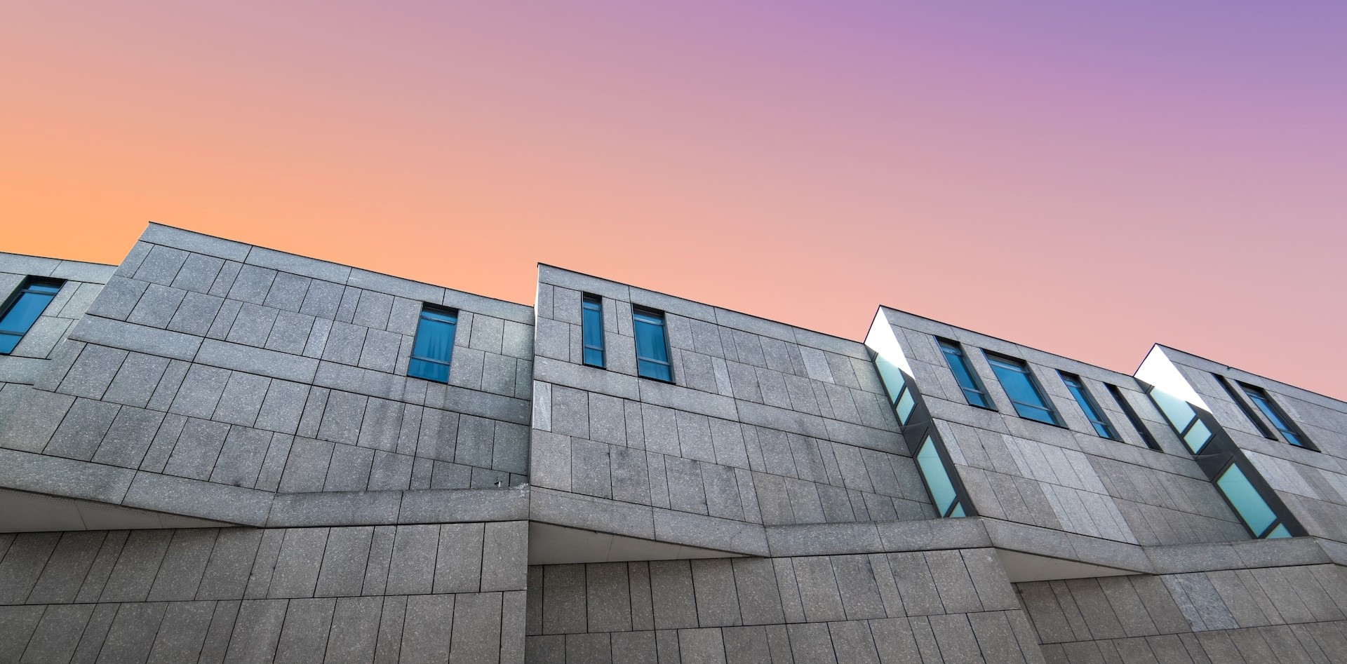 Angular concrete building against a sky at sunset