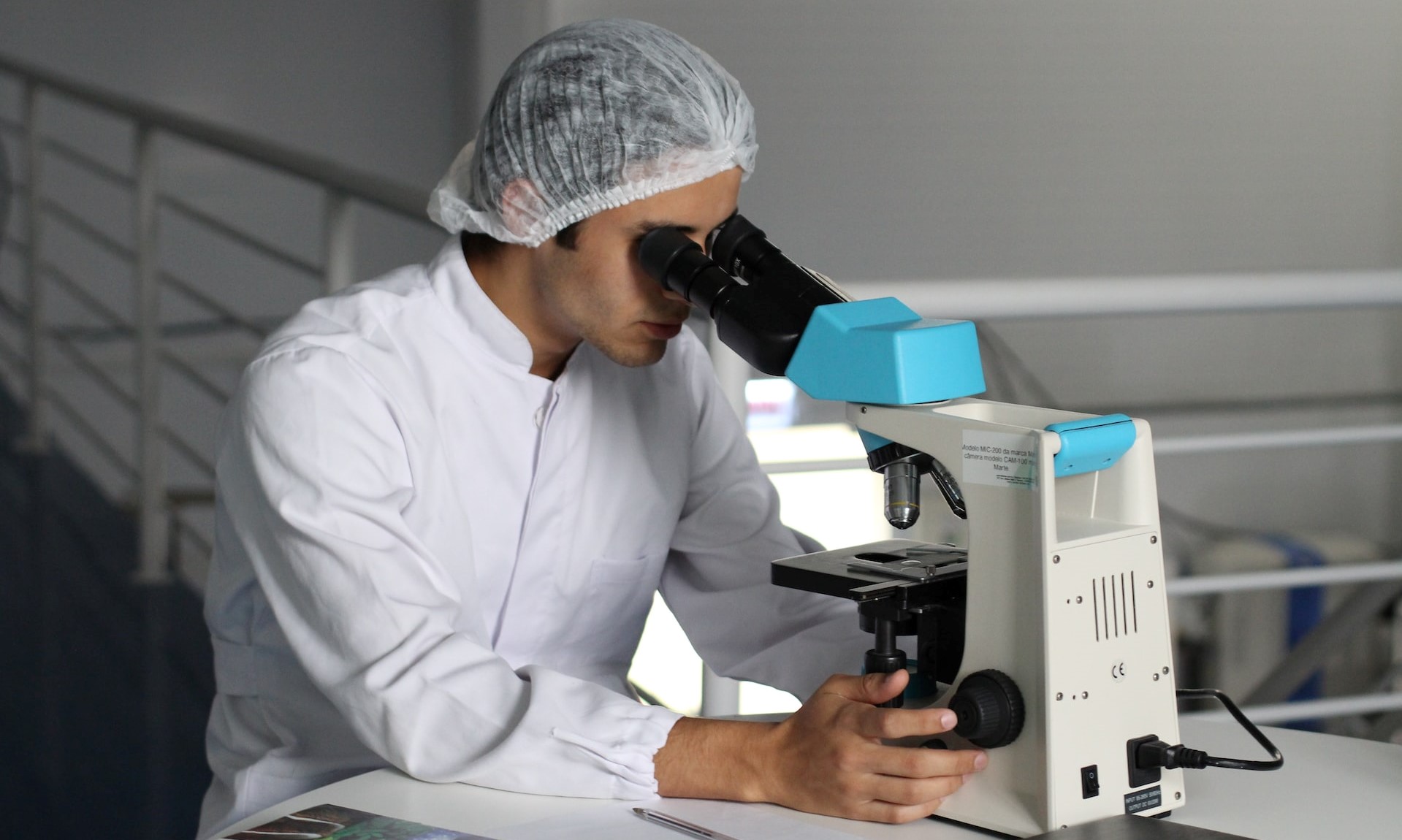 Medical researcher examines sample under microscope