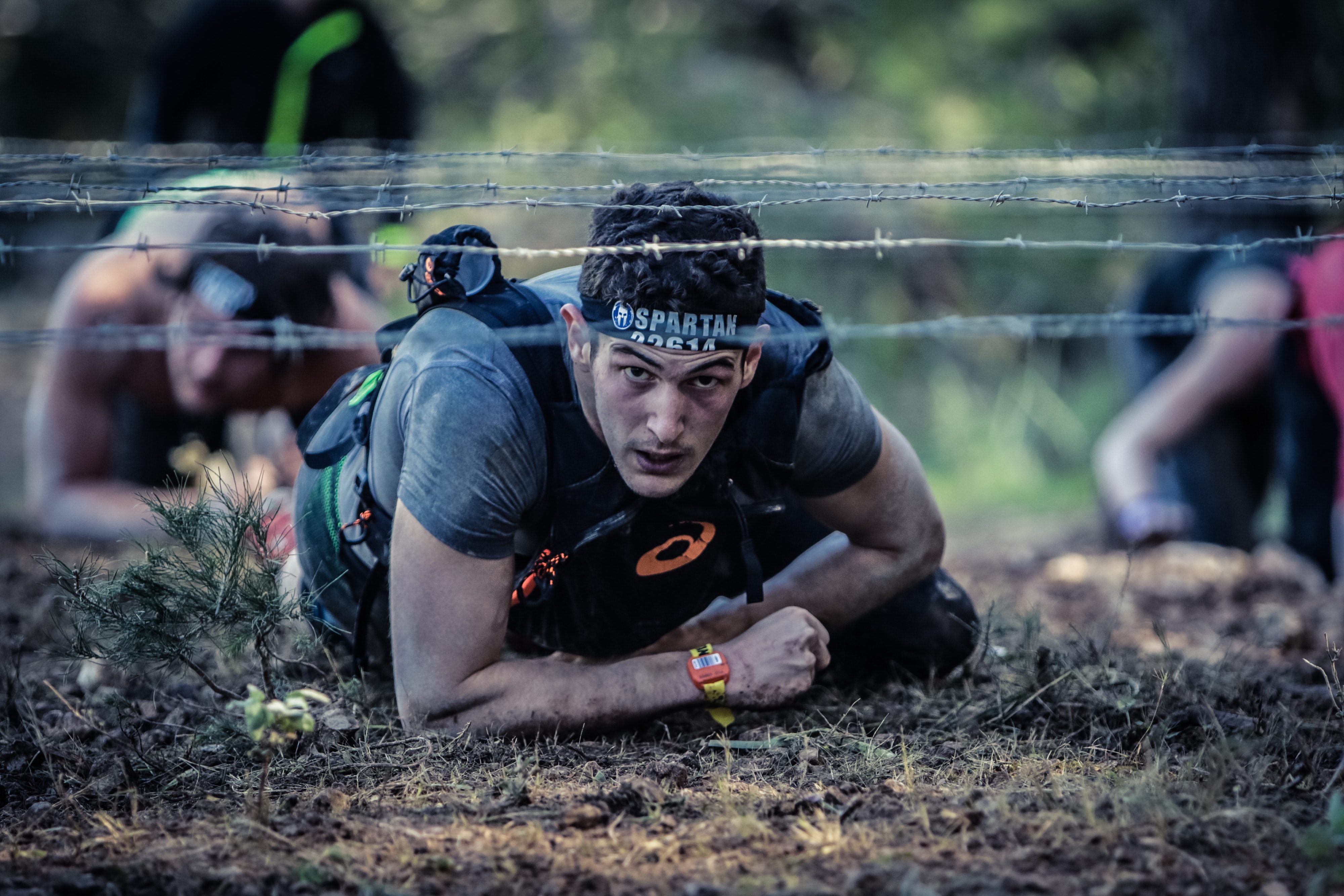 Man crawling under barbed wire