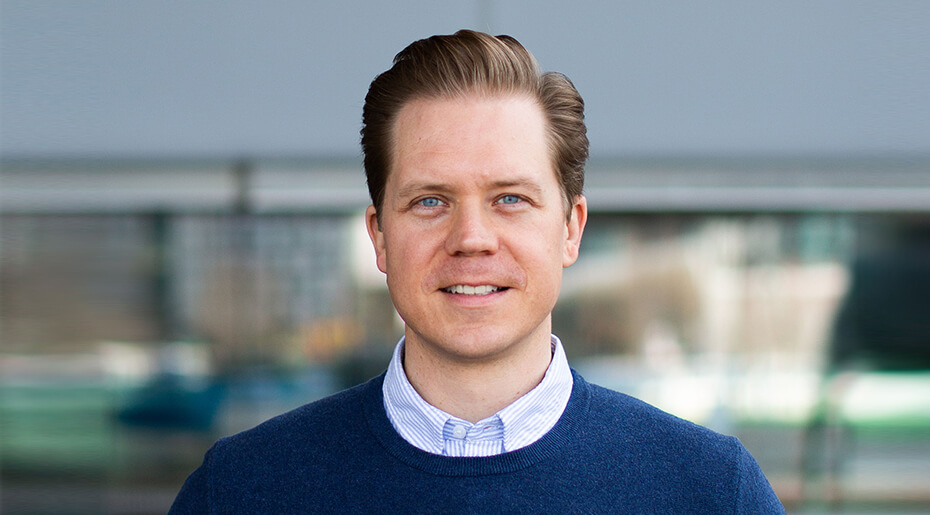 Headshot of Timothy Krysiek in a shirt and sweater