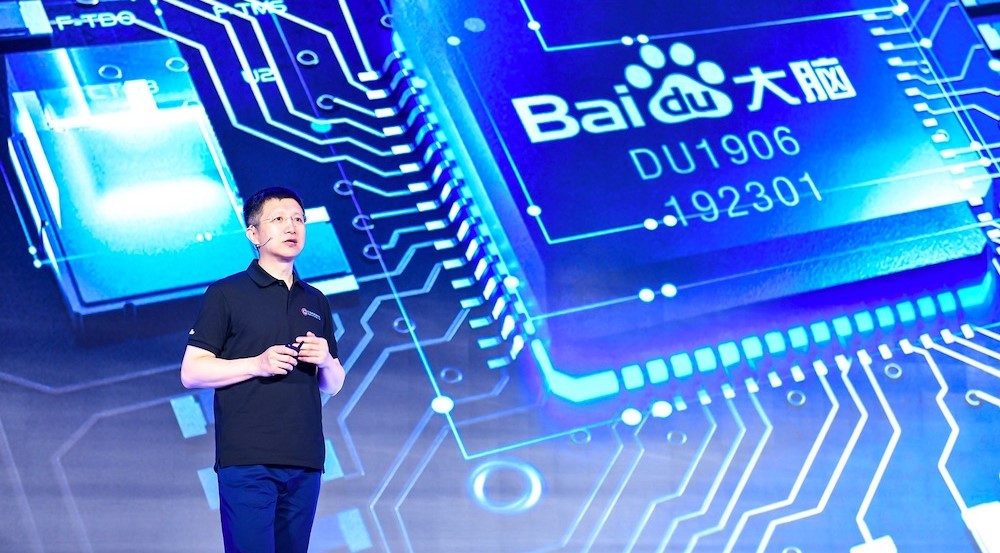 Man stands in front of a blue graphic representation of a Baidu microchip