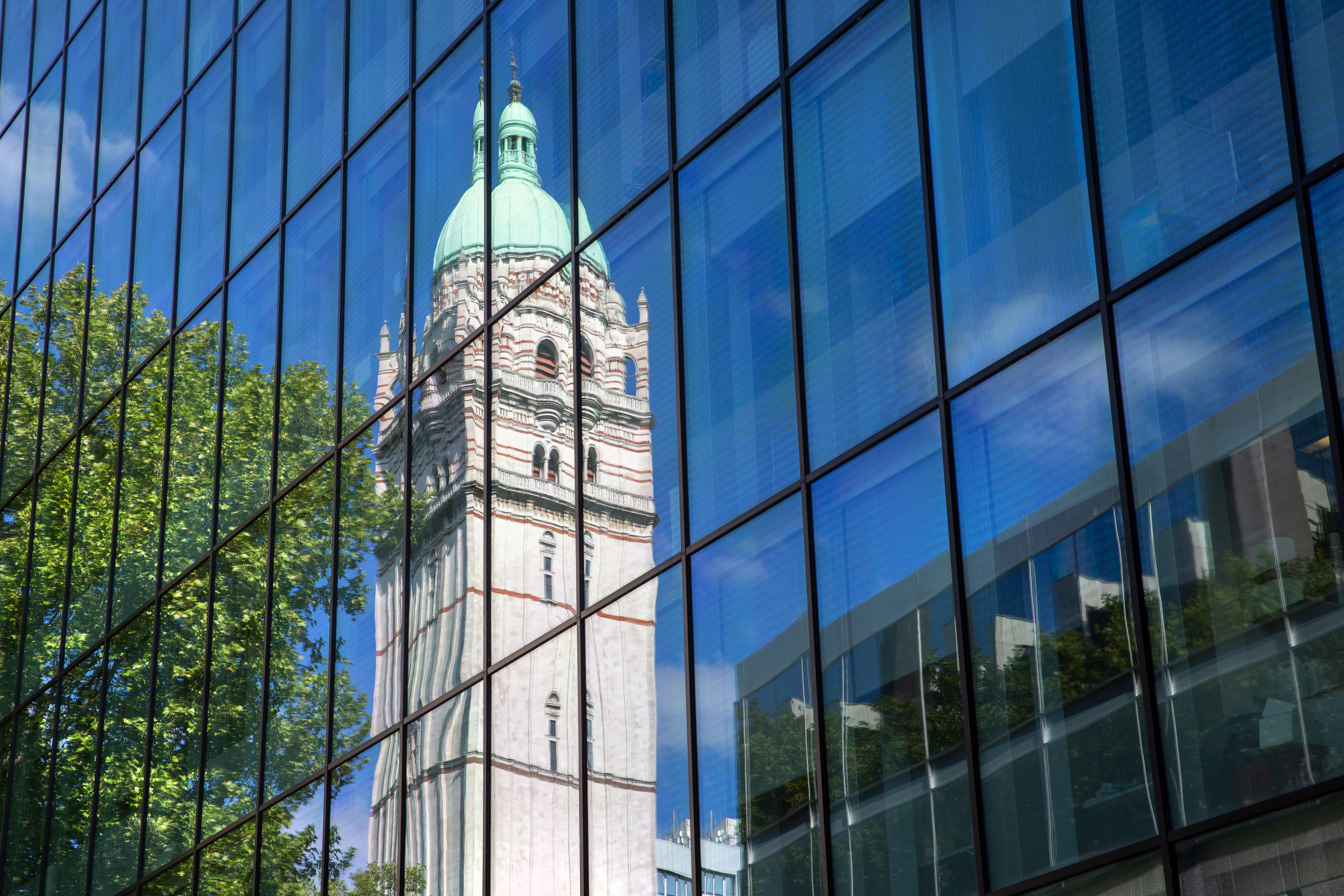 Imperial College London's tower reflected in a glass façade
