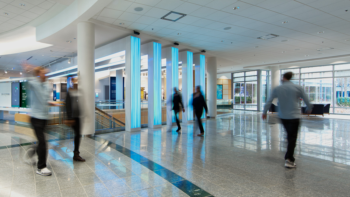 Blurry people walking through Cox lobby.