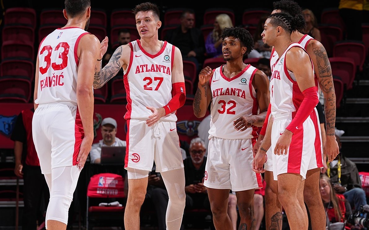 Atlanta Hawks players in white and red uniform talking to each other on court