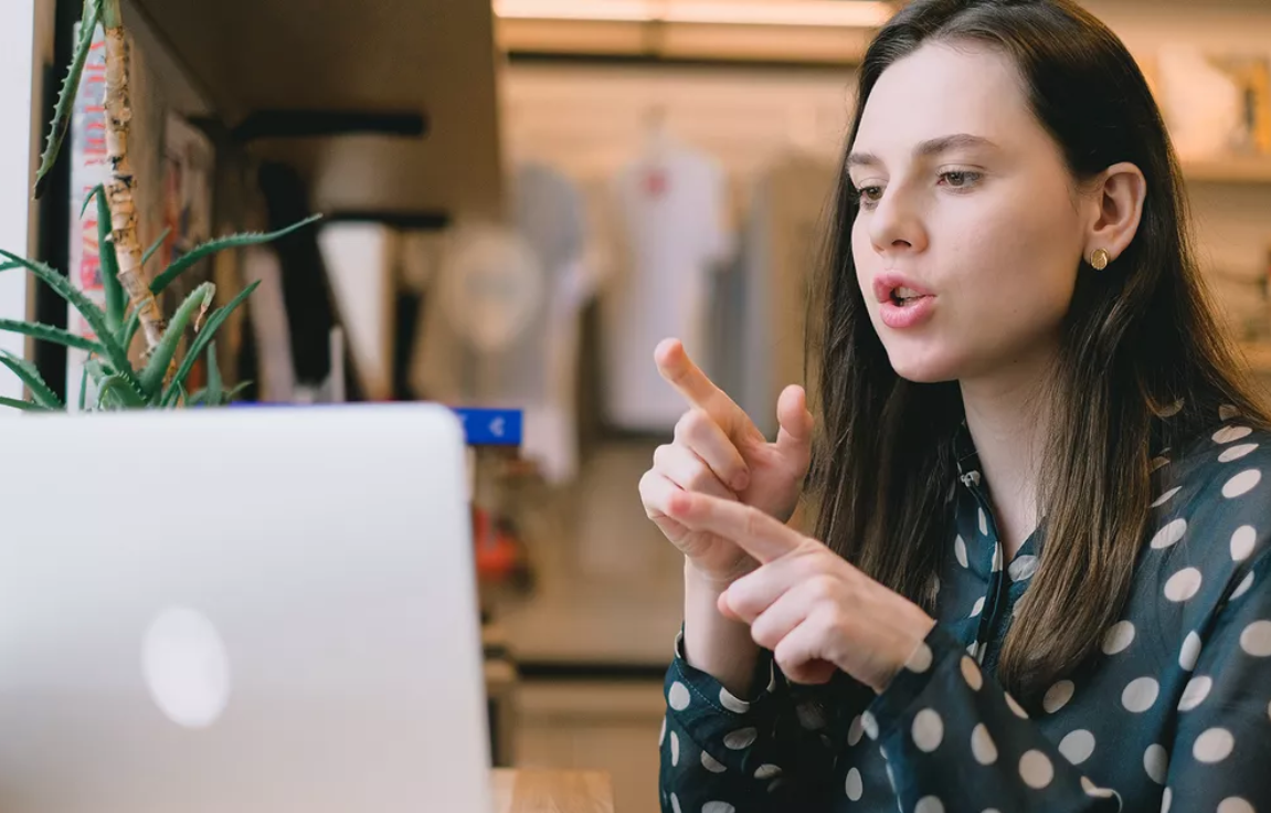 Gotudent tutor in polka dotted blouse communicates with student on laptop screen