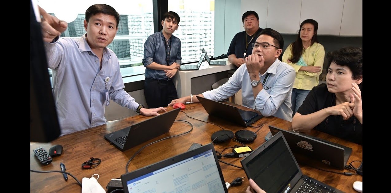 A man points to a screen for a group of Kasikorn Bank employees