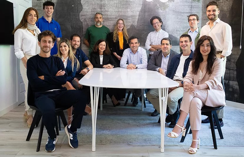 K Fund staff sitting and standing around a white table