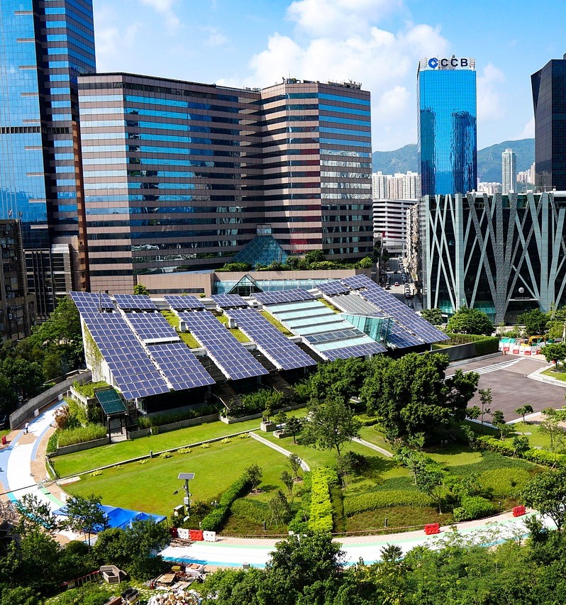 Solar panls installed on a grassy rooftop in a large city
