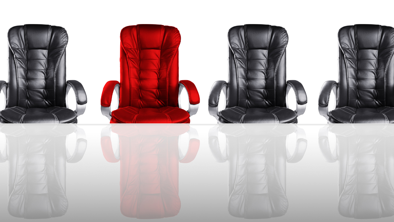A row of black office director's chair's with one red one