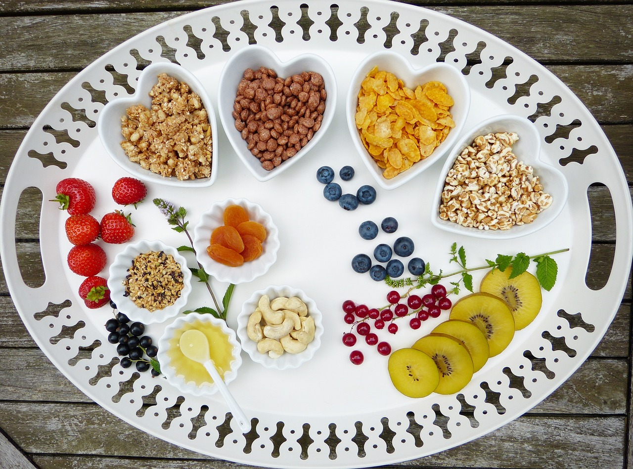 A white tray of assorted fruit, nuts and berries