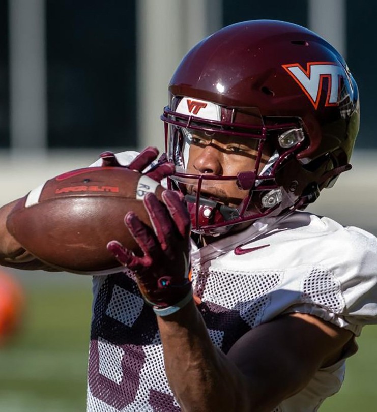 An American footballer in a Safr helmet catches a ball