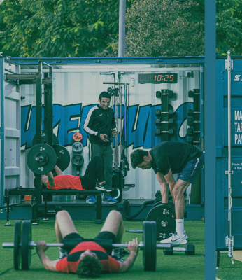 People lift weights in a Supercubo shipping container gym facility