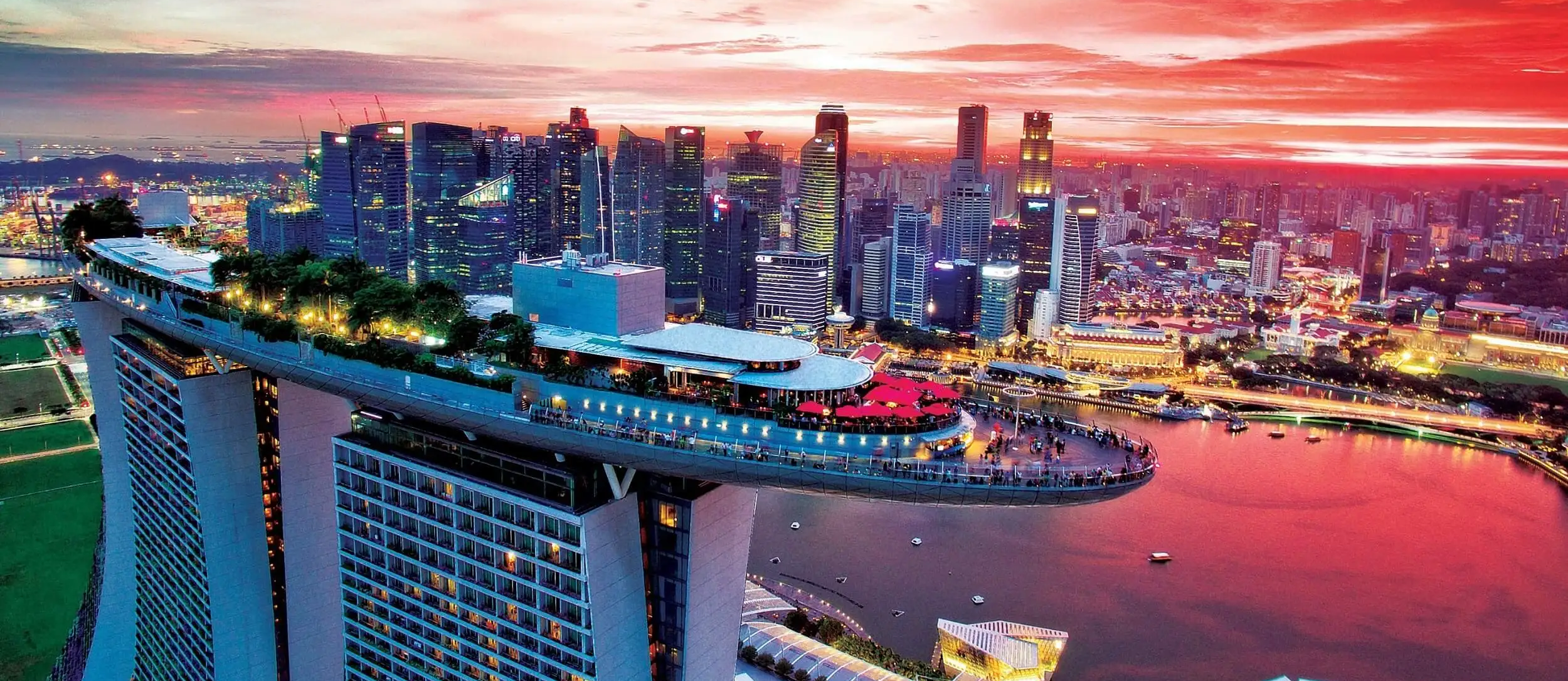 A drone photo of the CE LA VI rooftop restaurant and bar at sunset, with the Singapore skyline behind
