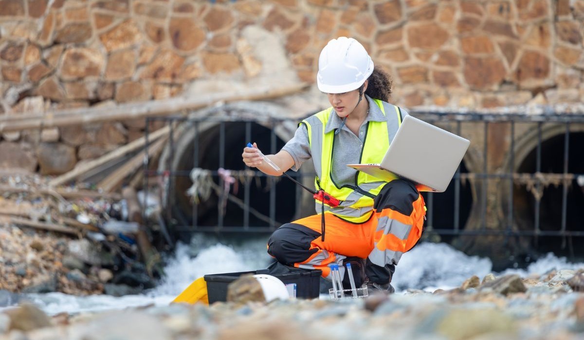 Environmental engineer testing water quality in urban drainage
