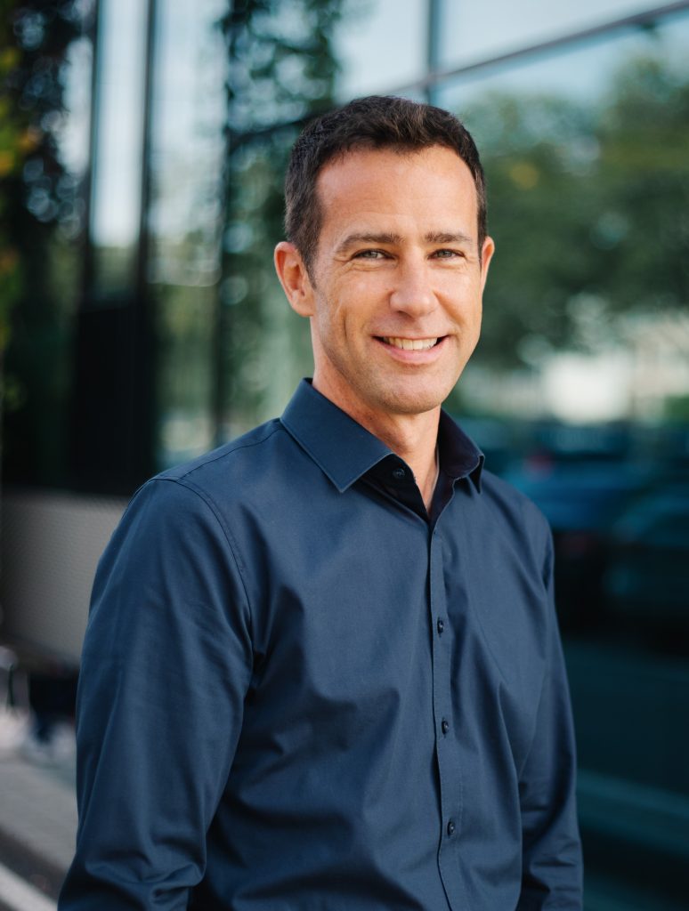 Crispin Leick standing in a blue shirt