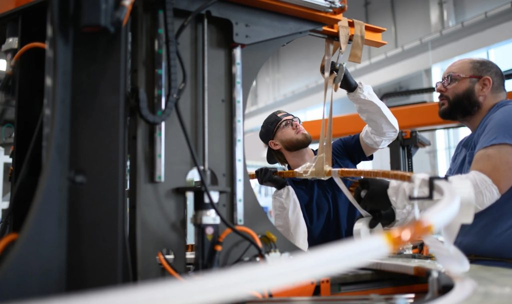 Two men with goggles examining something in an industrial laboratory