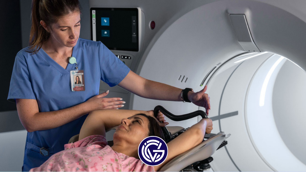 A woman feeds a female patient into an MRI, with the GCV logo overlaying