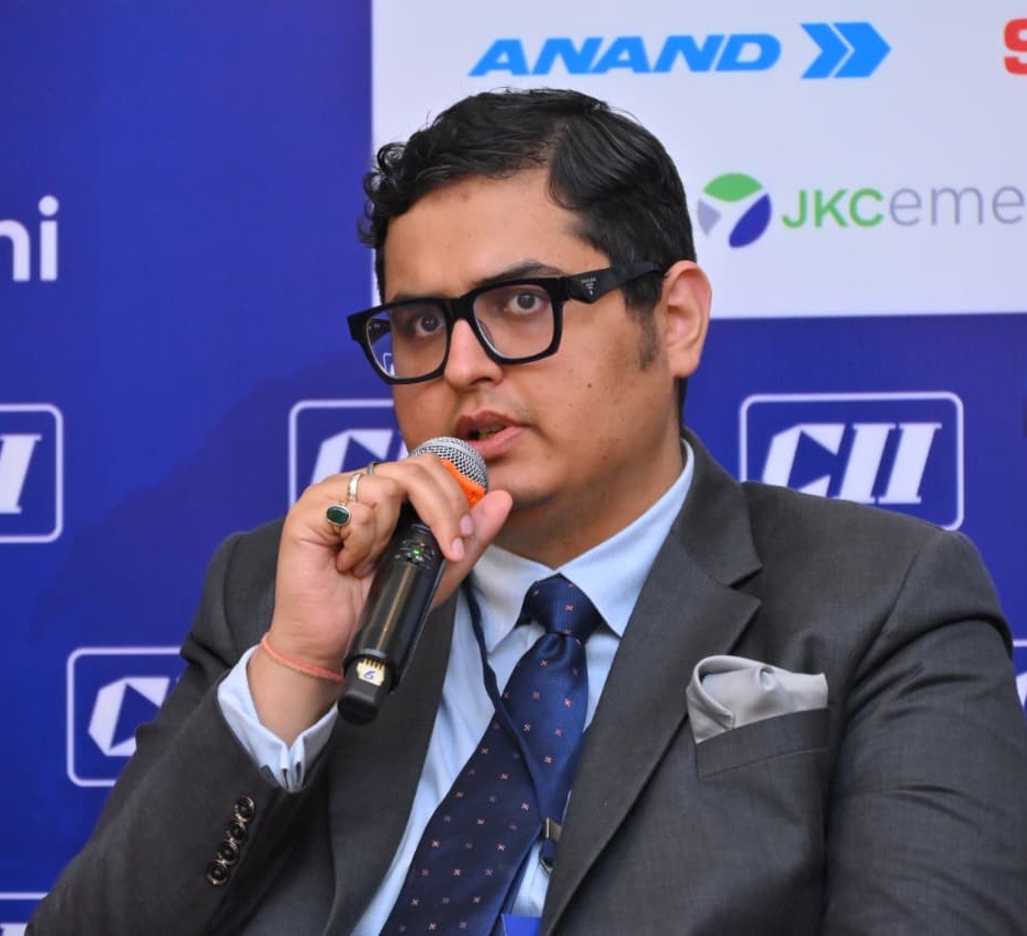 Ankit Harjai sitting and speaking into a microphone at a conference